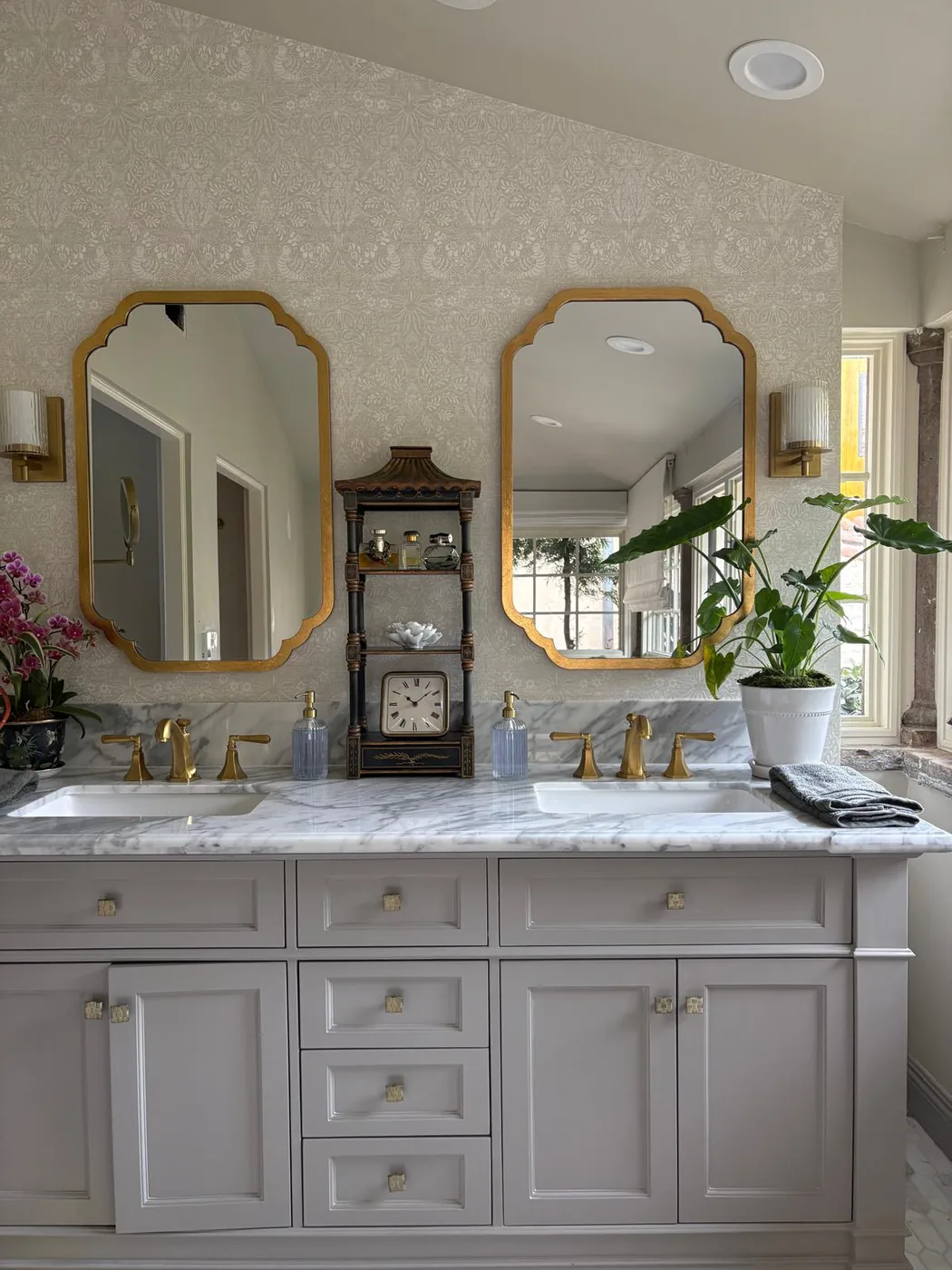 Double vanity with gold mirrors and marble top